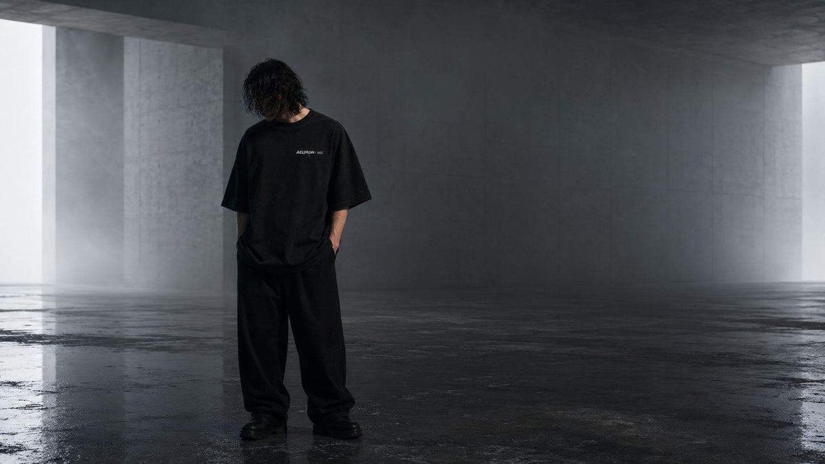 Silhouette dans un corridor de béton — proportions et port d’un t-shirt oversize graphique