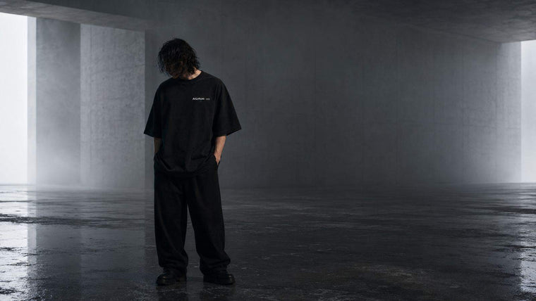 Silhouette dans un corridor de béton — proportions et port d’un t-shirt oversize graphique