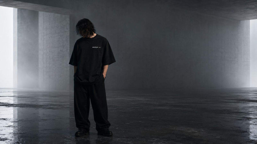 Silhouette dans un corridor de béton — proportions et port d’un t-shirt oversize graphique